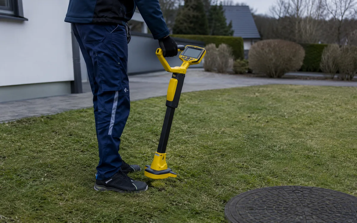 Tekniker som söker ledning med mottagare över marken